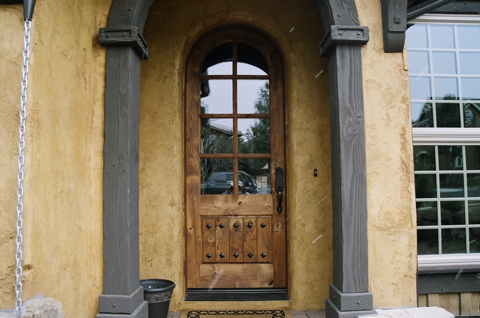 Immagine di una piccola porta d'ingresso rustica con una porta singola e una porta in vetro