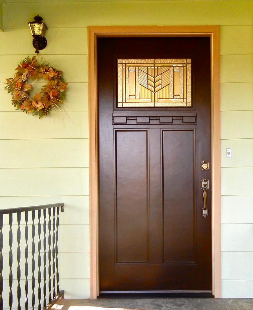 Cette image montre une porte d'entrée craftsman avec une porte simple et une porte en bois foncé.