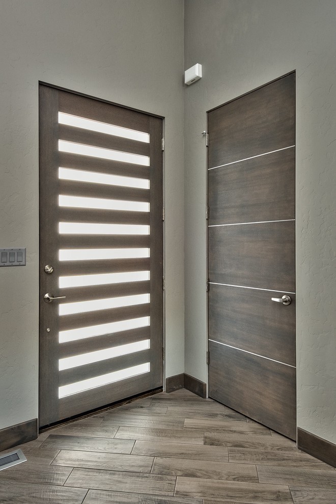 Idee per una porta d'ingresso minimalista di medie dimensioni con pareti grigie, parquet scuro, una porta singola, una porta in legno scuro e pavimento marrone