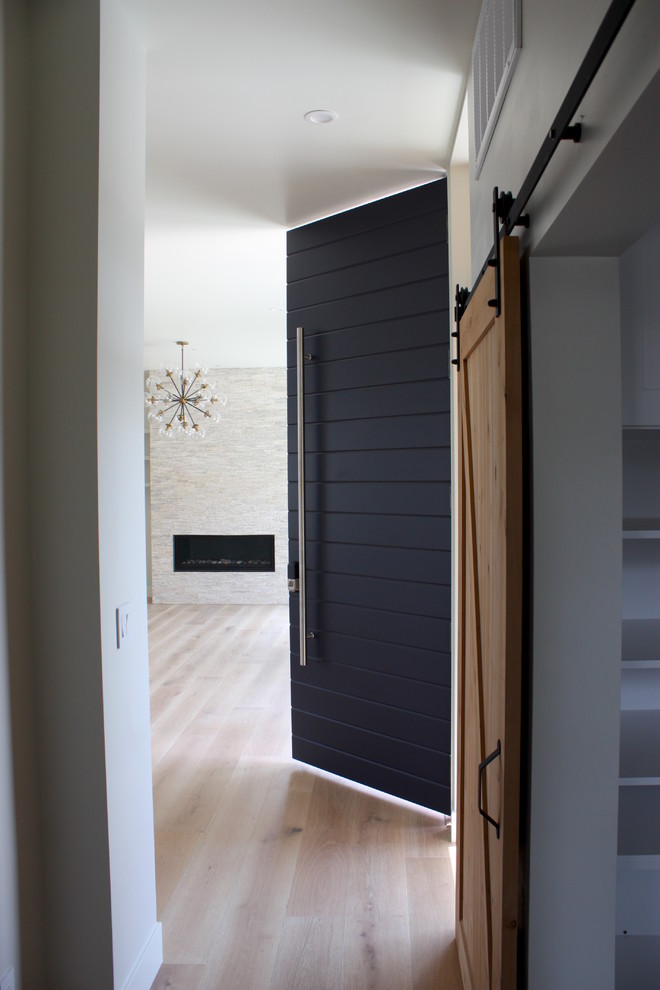 Foto de puerta principal moderna extra grande con paredes blancas, suelo de madera clara, puerta simple, puerta azul y suelo marrón