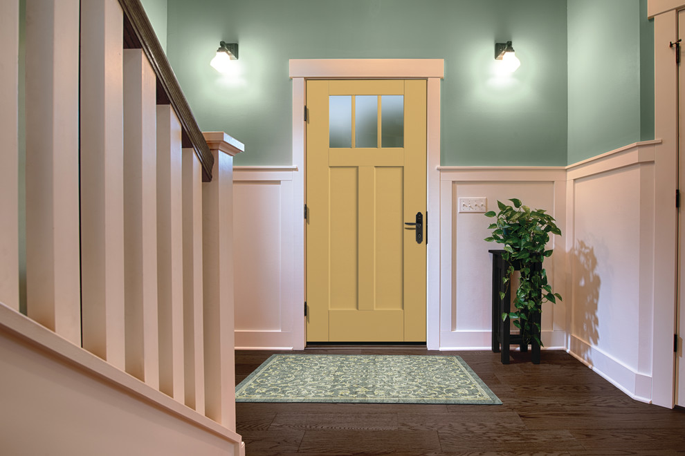Inredning av en klassisk mellanstor ingång och ytterdörr, med mörkt trägolv, en enkeldörr, brunt golv, gröna väggar och en gul dörr