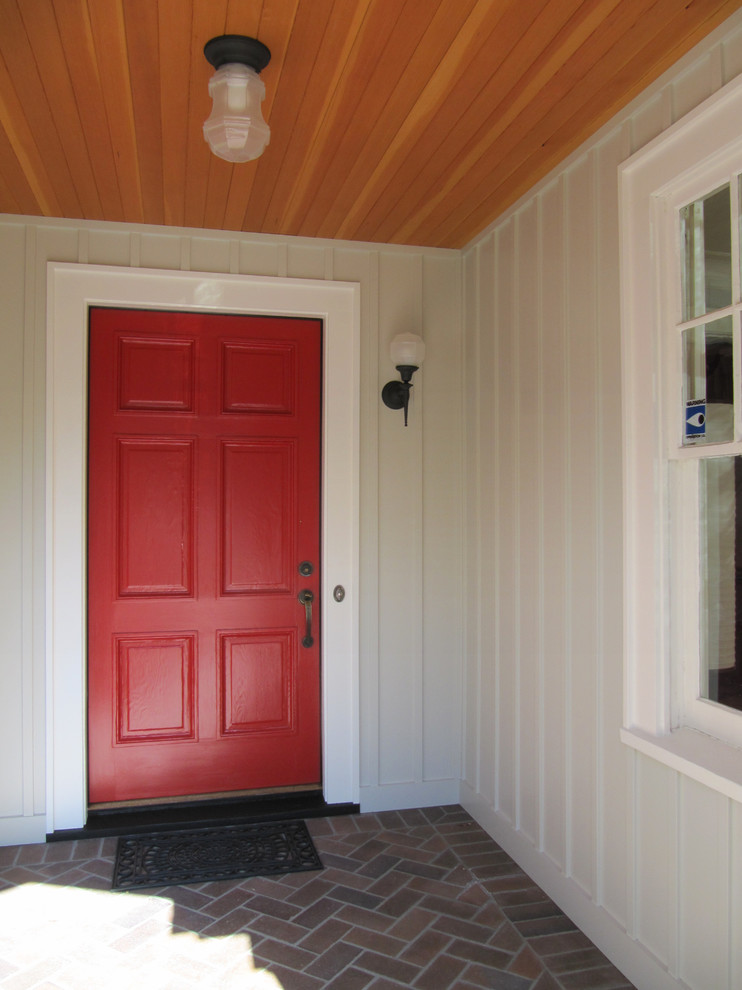 Idée de décoration pour un petit vestibule tradition avec un mur gris, une porte simple et une porte rouge.