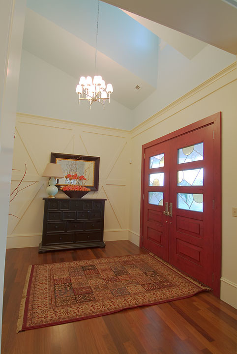 ソルトレイクシティにある中くらいなカントリー風のおしゃれな玄関ドア (ベージュの壁、無垢フローリング、赤いドア) の写真
