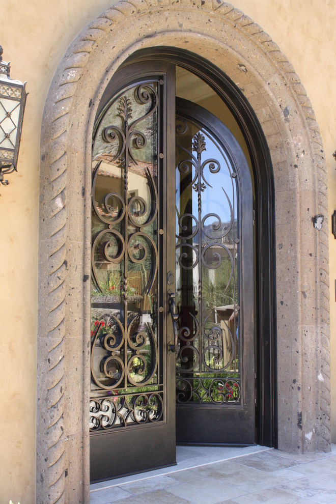 Идея дизайна: входная дверь среднего размера в средиземноморском стиле с коричневыми стенами, полом из травертина, двустворчатой входной дверью, стеклянной входной дверью и бежевым полом