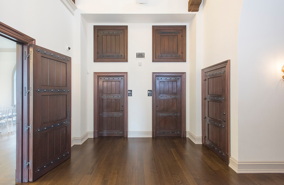 Ejemplo de vestíbulo de tamaño medio con paredes blancas, suelo de madera pintada, puerta pivotante, puerta marrón y suelo marrón