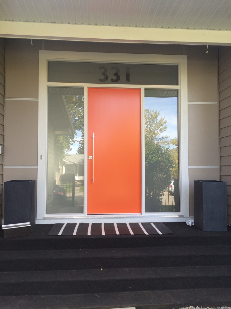 Foto di una grande porta d'ingresso moderna con pareti beige, una porta singola e una porta arancione