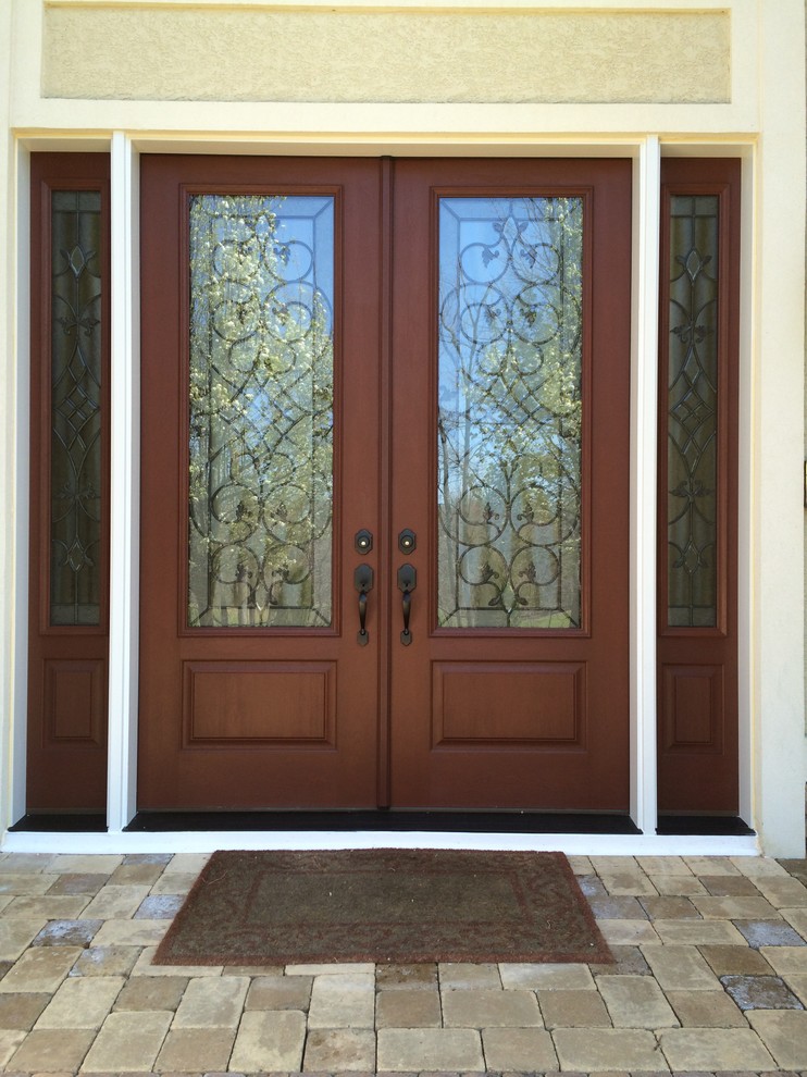 На фото: большая входная дверь в классическом стиле с двустворчатой входной дверью и входной дверью из темного дерева