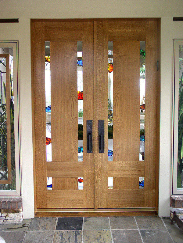 На фото: входная дверь среднего размера в стиле модернизм с полом из сланца, двустворчатой входной дверью и входной дверью из дерева среднего тона с