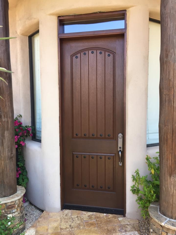 フェニックスにあるお手頃価格の中くらいなサンタフェスタイルのおしゃれな玄関ドア (ベージュの壁、磁器タイルの床、濃色木目調のドア) の写真