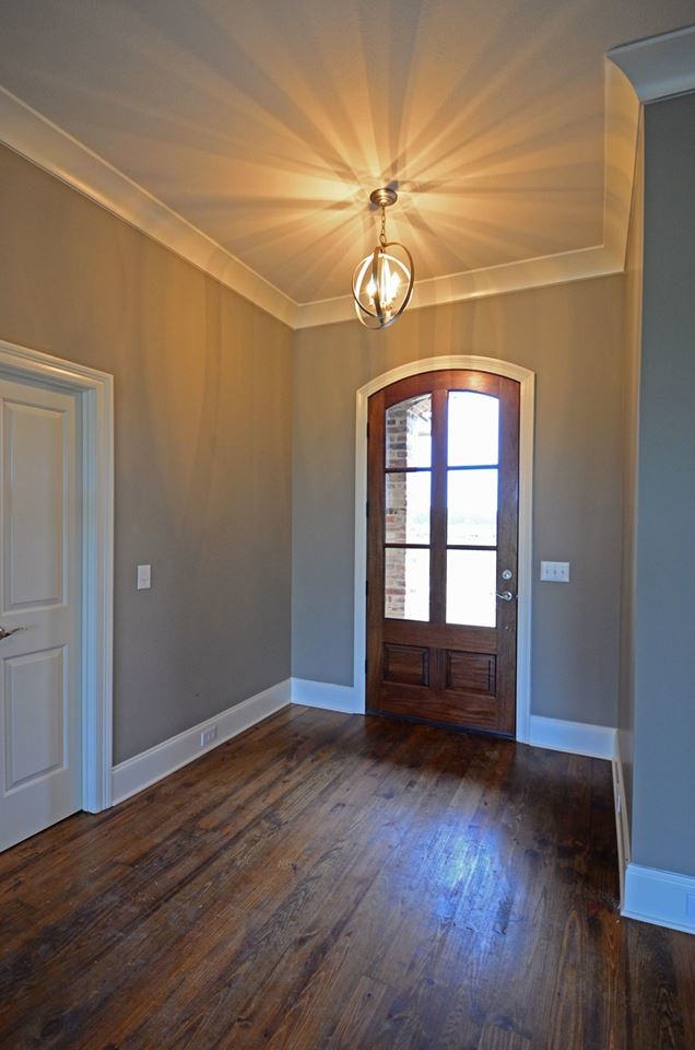 Cette image montre un hall d'entrée traditionnel de taille moyenne avec un mur gris, un sol en bois brun, une porte simple et une porte en bois brun.