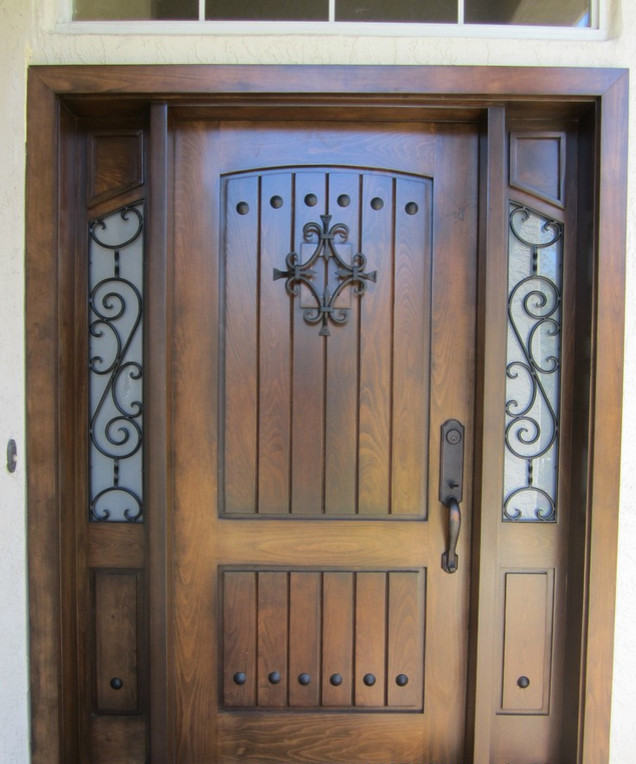 Foto di un ingresso mediterraneo con una porta singola e una porta in legno bruno