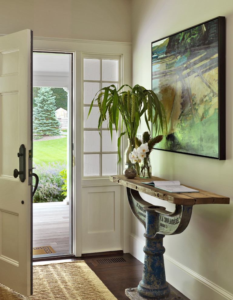 This is an example of a rural porch in Boston with beige walls and a white front door.