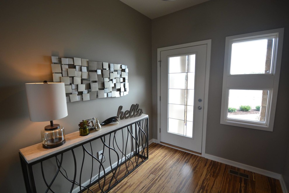 Mittelgroße Moderne Haustür mit grauer Wandfarbe, braunem Holzboden, Drehtür und weißer Haustür in Indianapolis