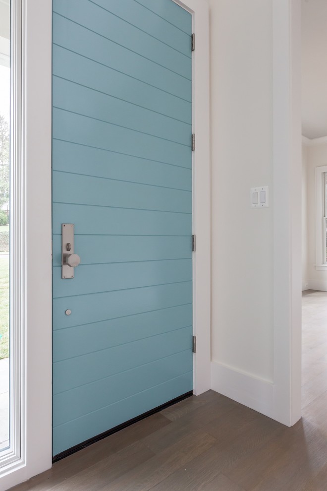 Idéer för funkis foajéer, med vita väggar, ljust trägolv, en enkeldörr, en blå dörr och grått golv