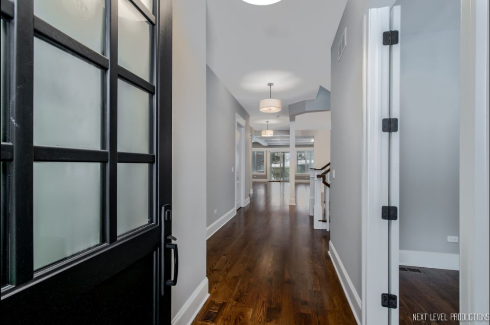 Mittelgroße Landhaus Haustür mit grauer Wandfarbe, braunem Holzboden, Einzeltür, schwarzer Haustür und braunem Boden in Chicago
