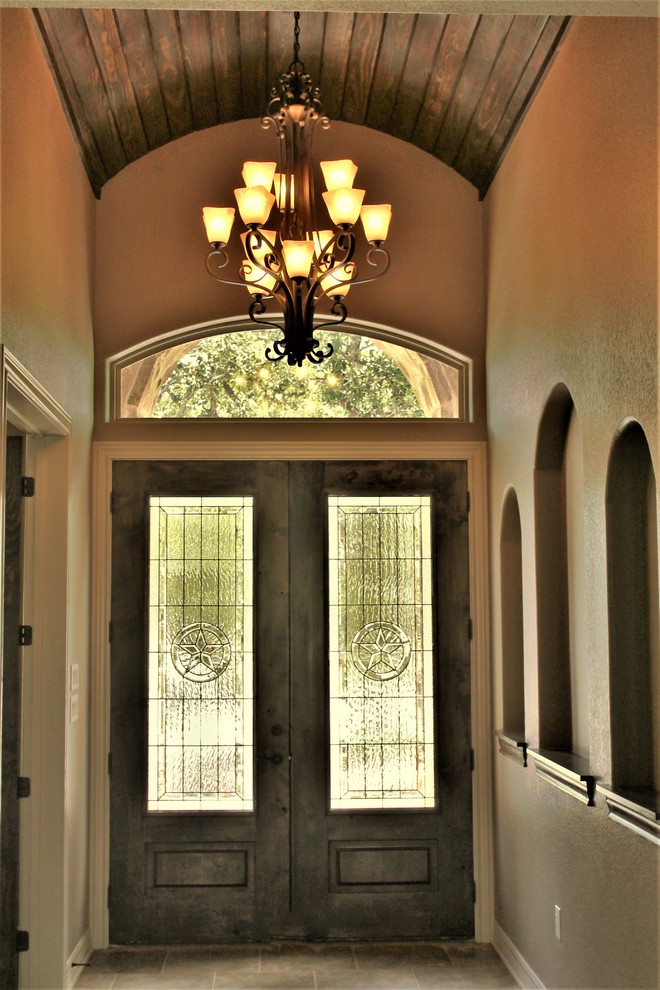 Ispirazione per una grande porta d'ingresso stile rurale con pareti beige, pavimento in gres porcellanato, una porta a due ante, una porta in legno scuro e pavimento beige