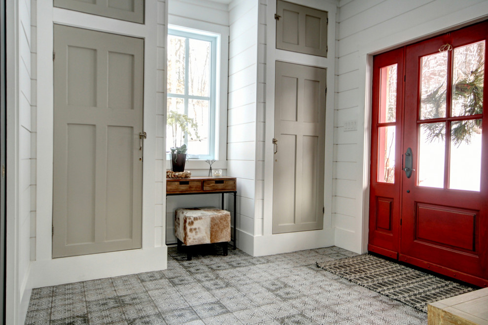 他の地域にある高級な広いカントリー風のおしゃれな玄関ドア (白い壁、セラミックタイルの床、赤いドア、白い床) の写真