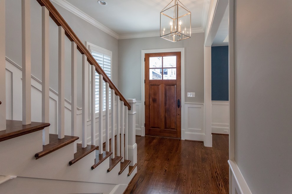Inspiration for a traditional hallway in DC Metro with beige walls, medium hardwood flooring, a single front door, a medium wood front door and brown floors.