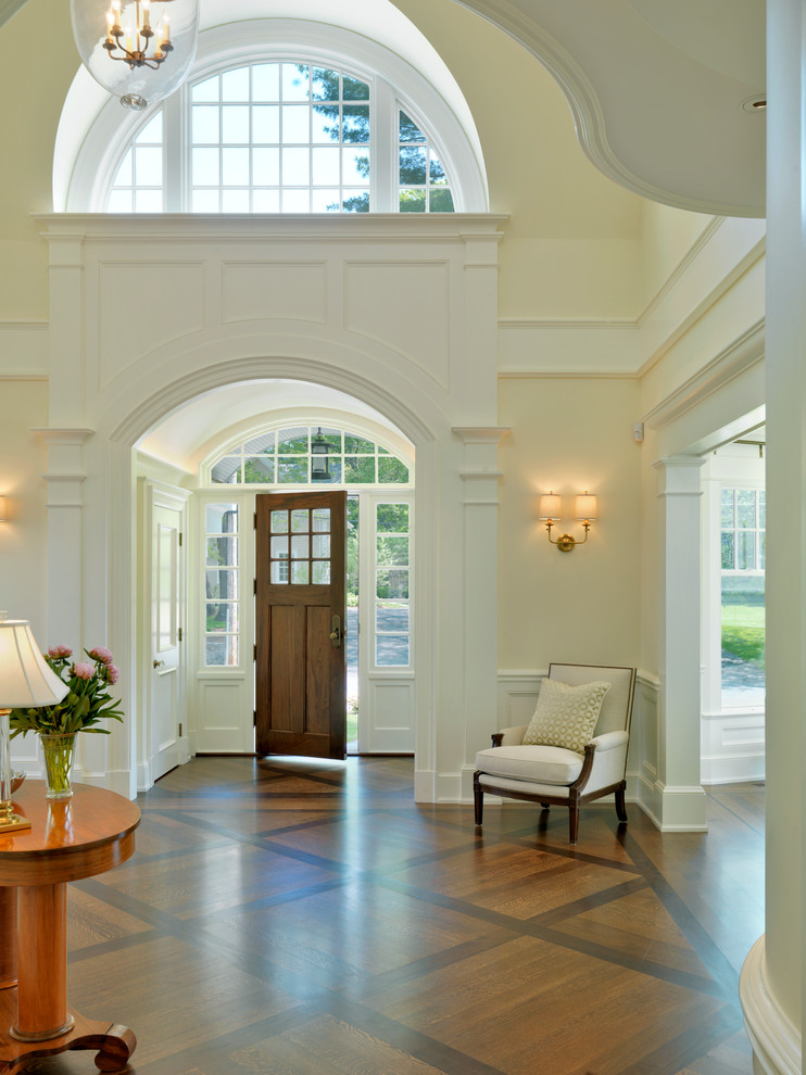 Klassisches Foyer mit dunklem Holzboden, Einzeltür, dunkler Holzhaustür und beiger Wandfarbe in Boston