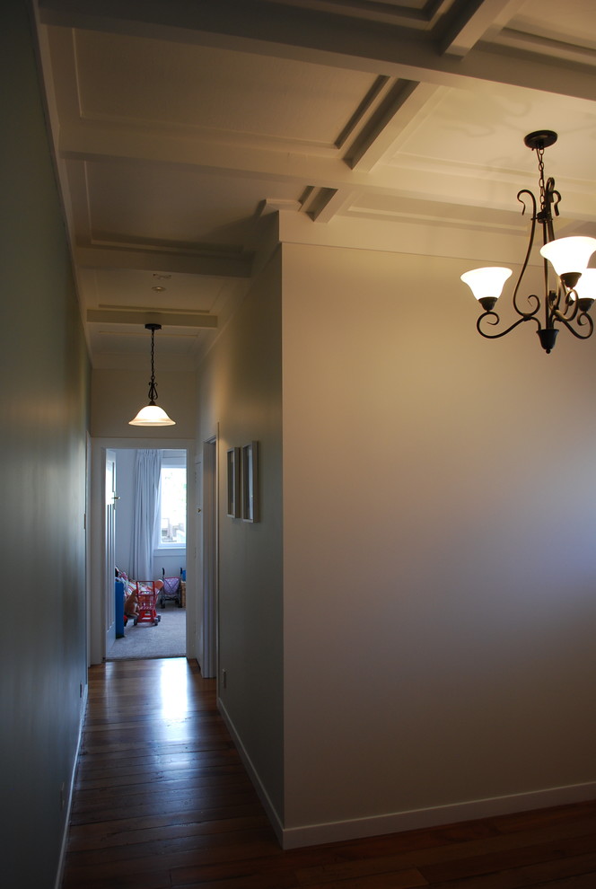 Esempio di un corridoio tradizionale con pareti beige, una porta singola, parquet chiaro e una porta bianca