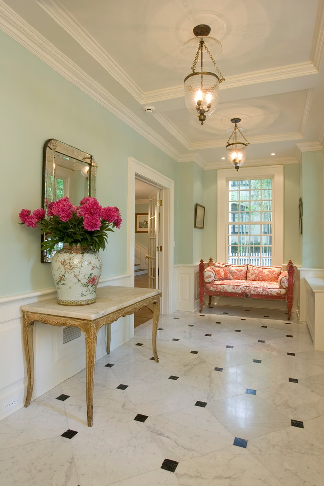 Réalisation d'une grande entrée tradition avec un couloir, un mur vert, un sol en marbre, un sol blanc et une porte simple.