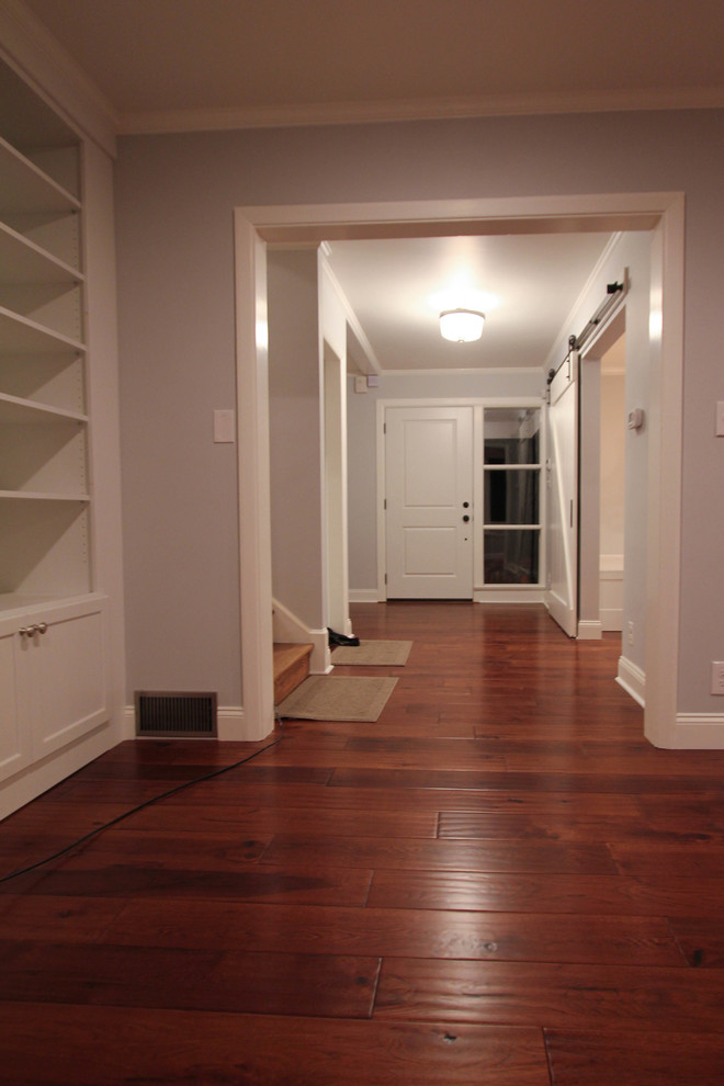 Example of a mid-sized farmhouse medium tone wood floor entryway design in Philadelphia with gray walls and a white front door