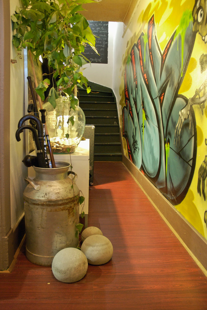 Exemple d'une entrée éclectique avec un couloir et un mur jaune.