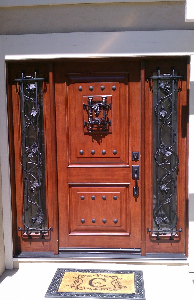 Foto di una porta d'ingresso stile rurale con una porta in legno bruno