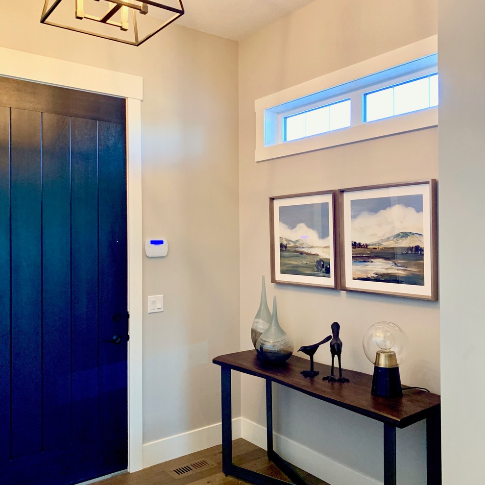 中くらいなトランジショナルスタイルのおしゃれな玄関ロビー (グレーの壁、無垢フローリング、濃色木目調のドア、グレーの床) の写真