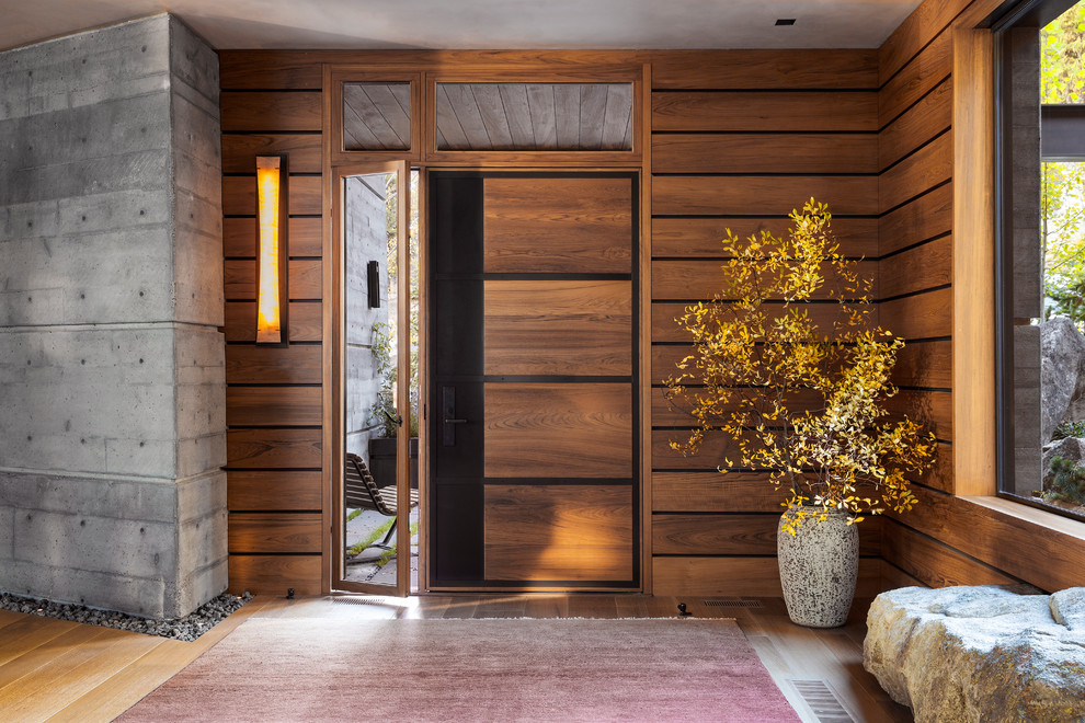Ejemplo de entrada minimalista con puerta simple y puerta de madera en tonos medios