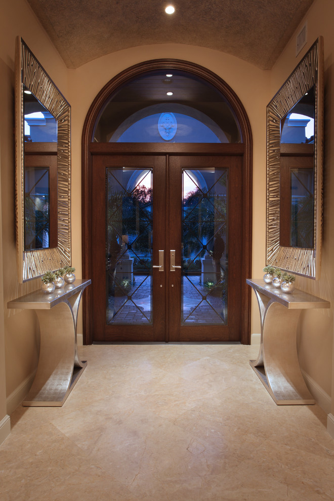 マイアミにあるコンテンポラリースタイルのおしゃれな玄関 (大理石の床、茶色いドア、白い床) の写真