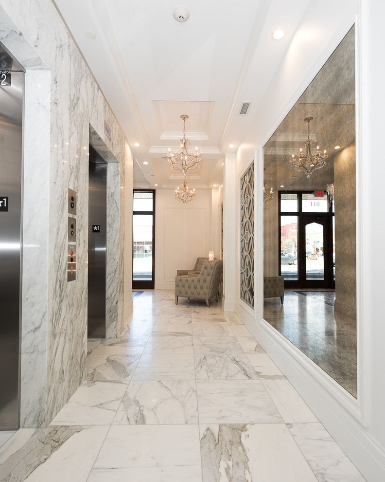 他の地域にある高級なトランジショナルスタイルのおしゃれな玄関 (白い壁、大理石の床、濃色木目調のドア、白い床) の写真