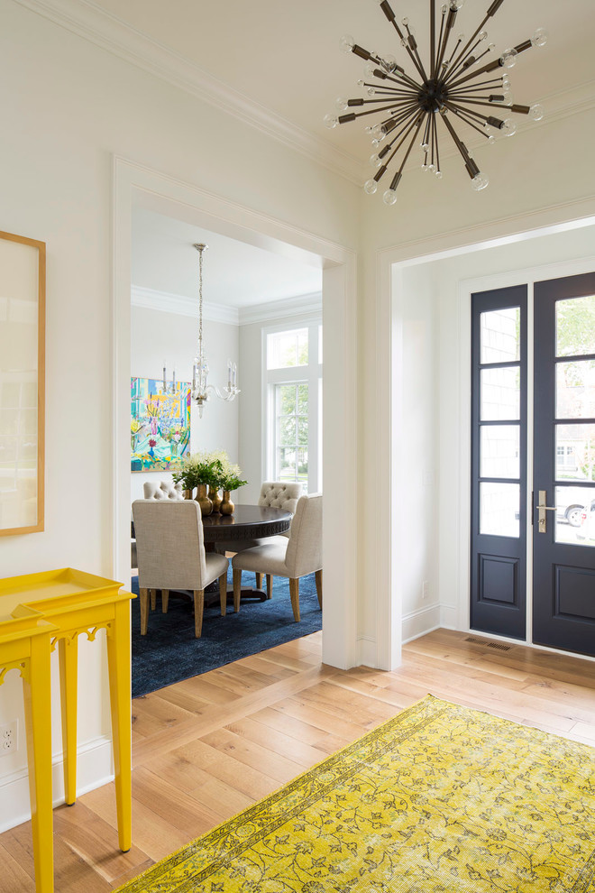 На фото: фойе среднего размера в современном стиле с белыми стенами, светлым паркетным полом, одностворчатой входной дверью, синей входной дверью и коричневым полом