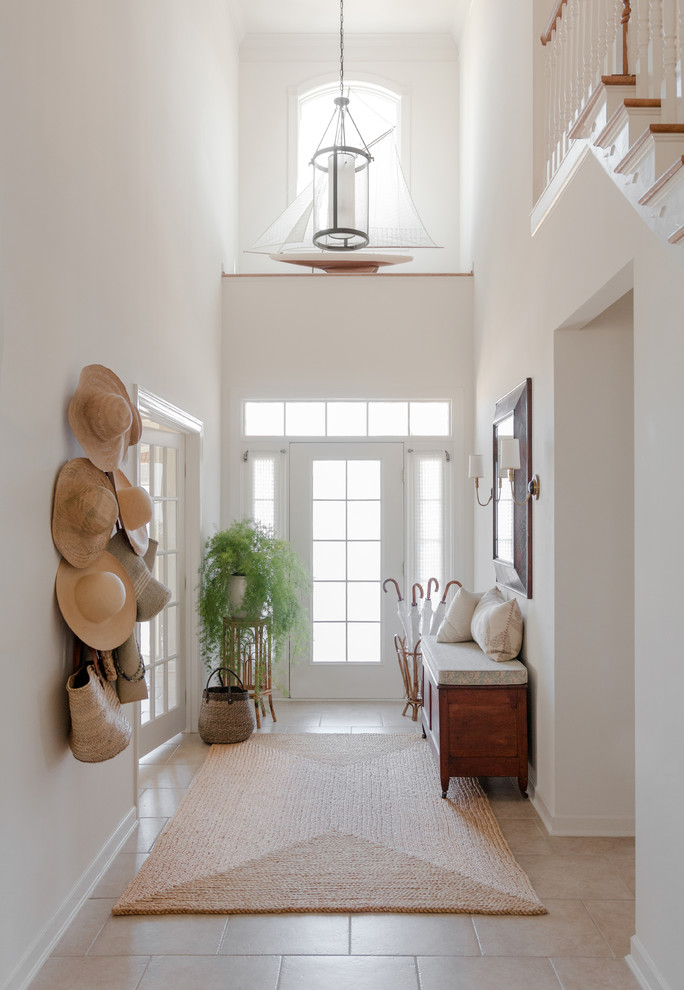 Immagine di un grande corridoio con pareti bianche, pavimento con piastrelle in ceramica, una porta singola e una porta bianca