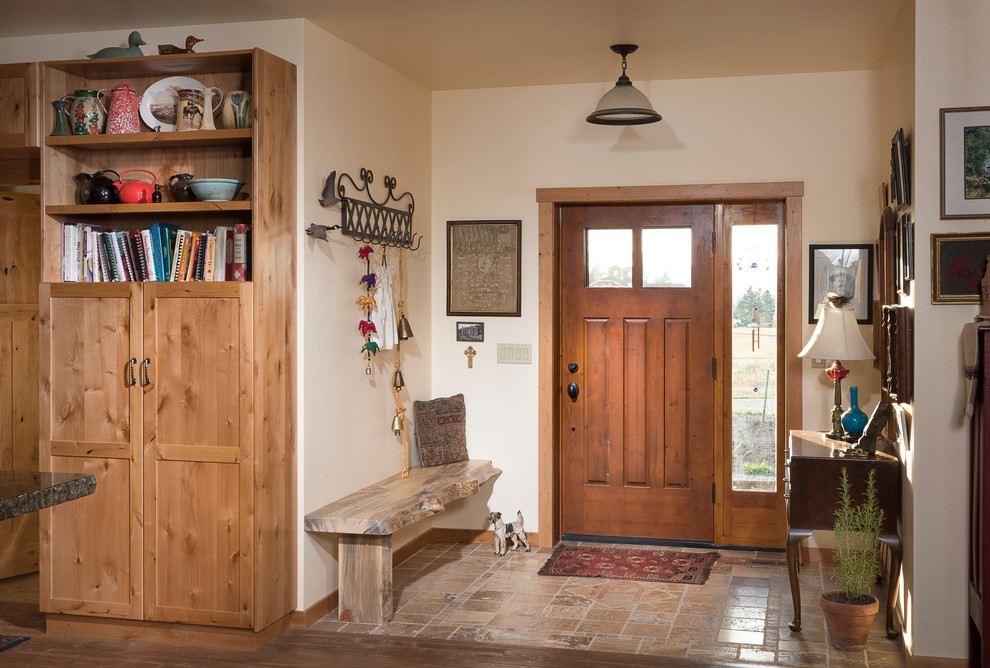 Cette image montre un hall d'entrée craftsman de taille moyenne avec tomettes au sol, une porte simple et une porte en bois brun.
