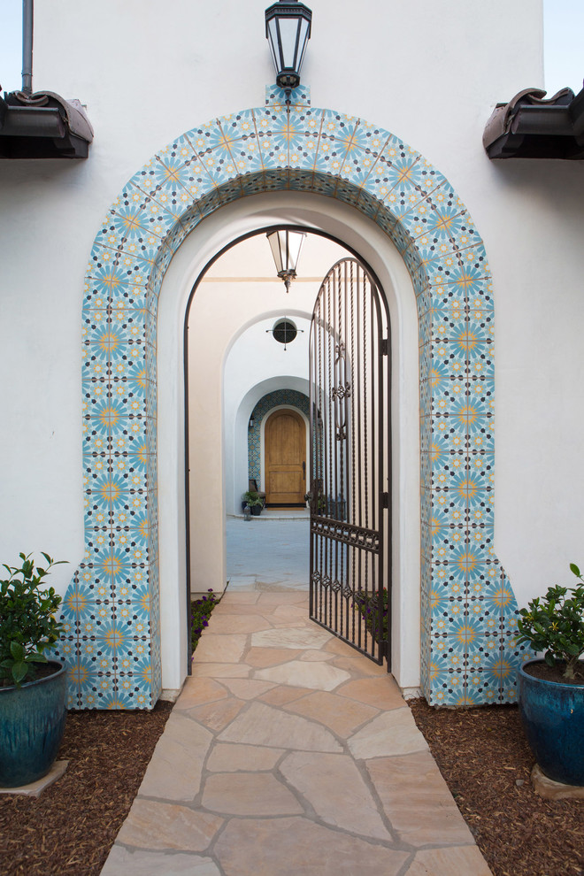 Источник вдохновения для домашнего уюта: большое фойе в средиземноморском стиле с белыми стенами, одностворчатой входной дверью и входной дверью из дерева среднего тона