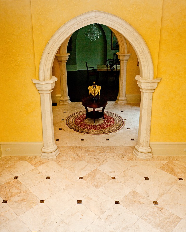 Foto på en medelhavsstil foajé, med gula väggar och travertin golv