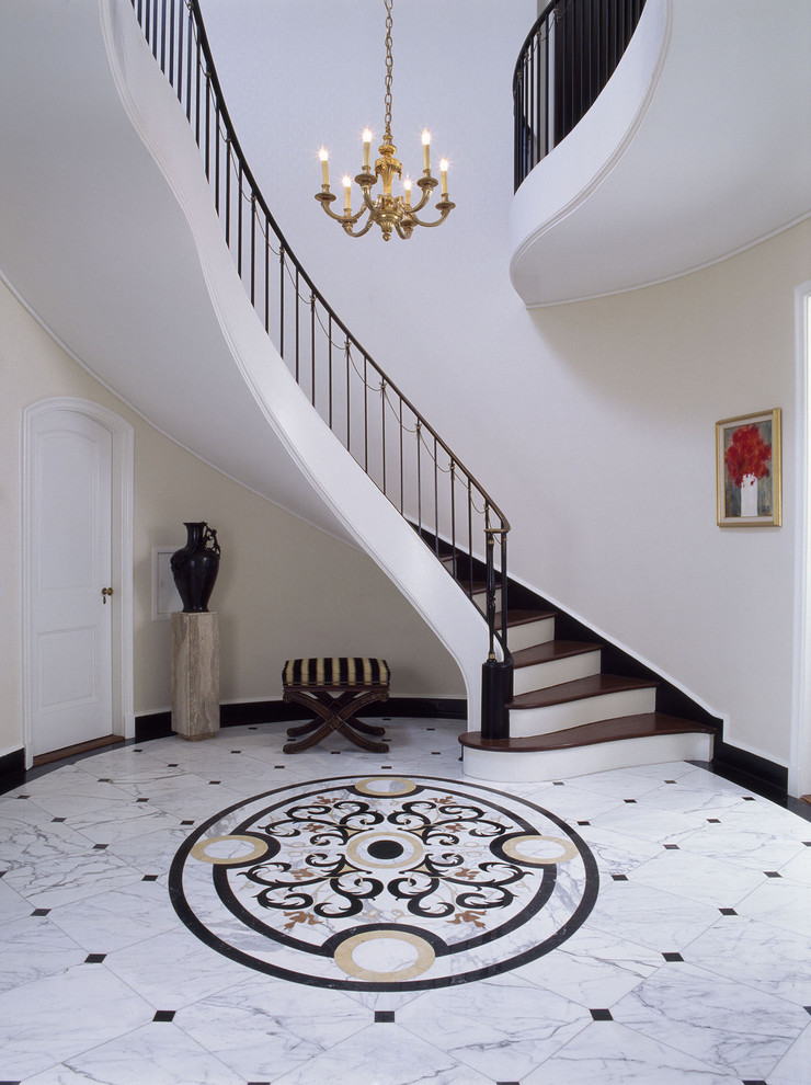 Huge elegant marble floor foyer photo in Santa Barbara with beige walls