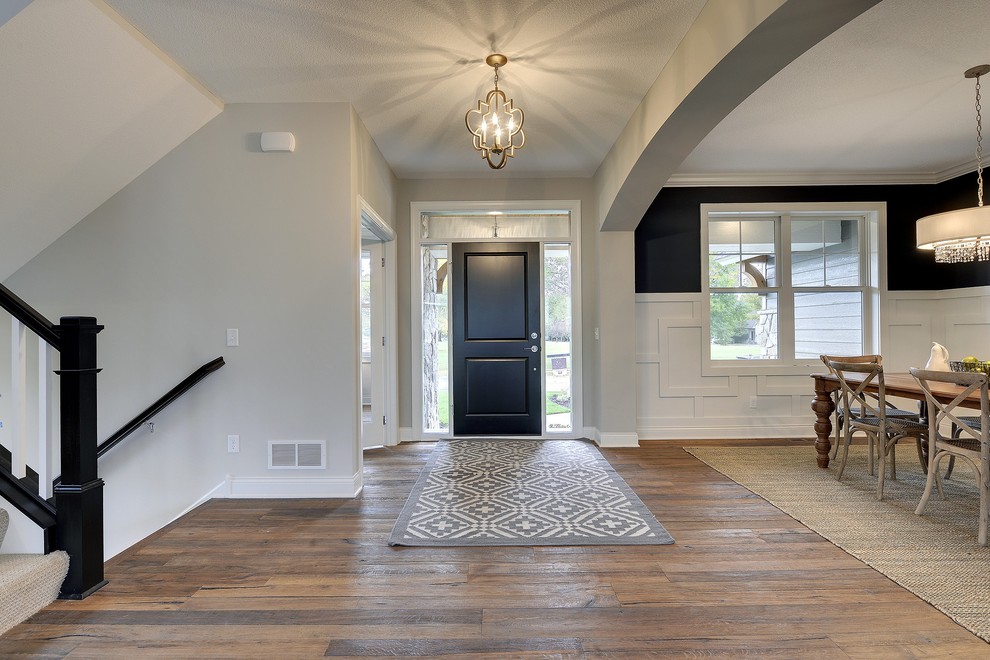 Example of a large transitional medium tone wood floor entryway design in Minneapolis with gray walls and a white front door