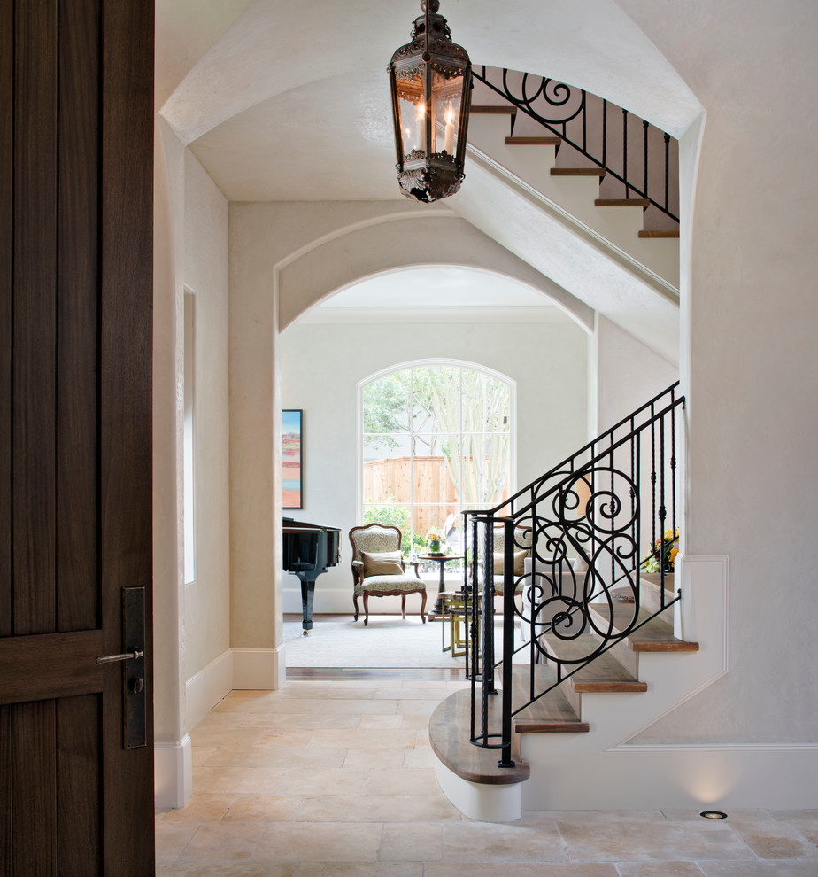 Mid-sized tuscan travertine floor entryway photo in Houston with beige walls and a dark wood front door