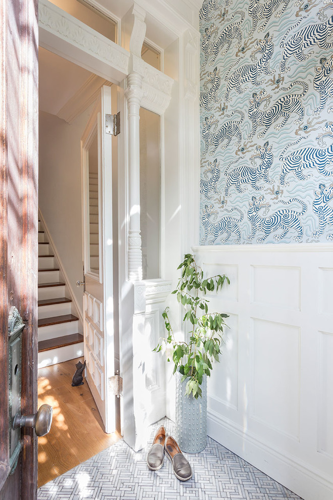 Cette image montre un hall d'entrée traditionnel de taille moyenne avec un mur multicolore, un sol en marbre, une porte simple et une porte blanche.