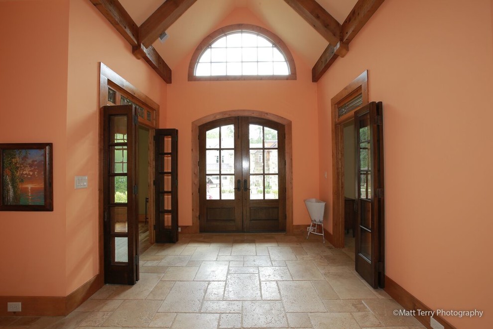 Idee per un grande ingresso mediterraneo con pareti arancioni, pavimento con piastrelle in ceramica, una porta a due ante e una porta in legno scuro