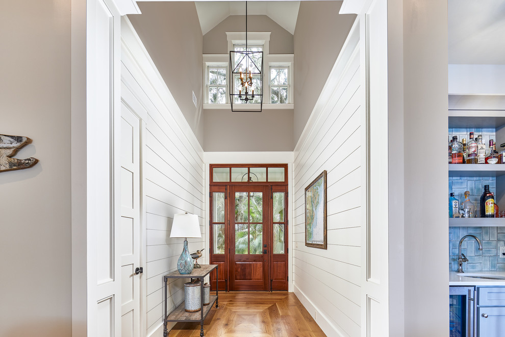 Источник вдохновения для домашнего уюта: большая входная дверь: освещение в морском стиле с белыми стенами, светлым паркетным полом, одностворчатой входной дверью, входной дверью из темного дерева и коричневым полом