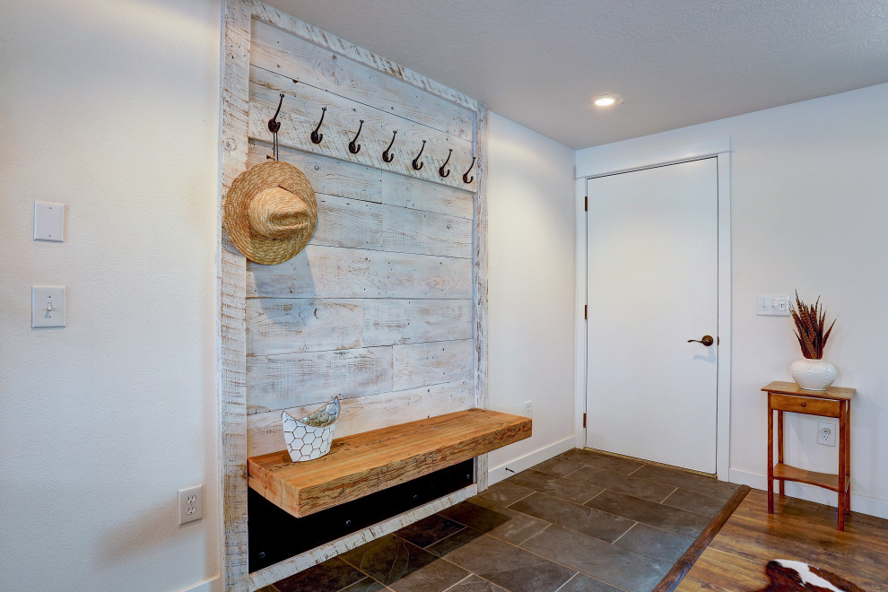Photo of a medium sized rustic foyer in Other with white walls, ceramic flooring, a single front door, a white front door and grey floors.