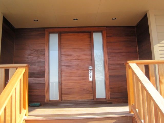 Mid-sized medium tone wood floor entryway photo in Boston with brown walls and a brown front door