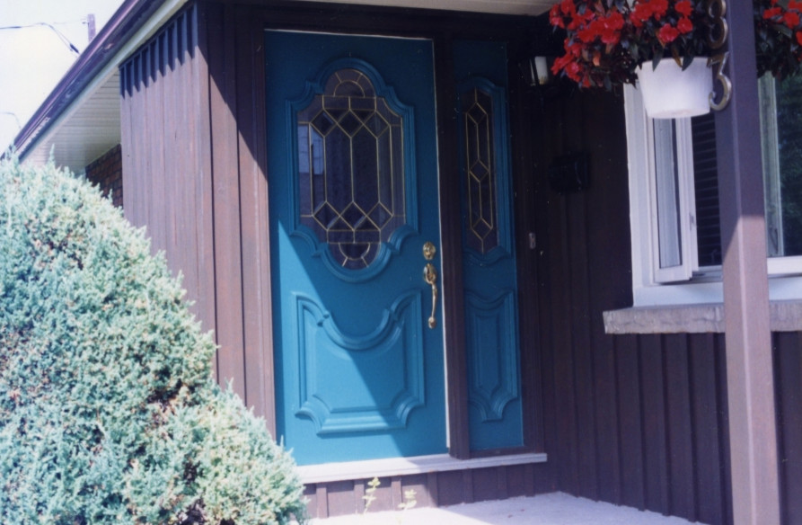 Immagine di un ingresso o corridoio con una porta singola e una porta blu