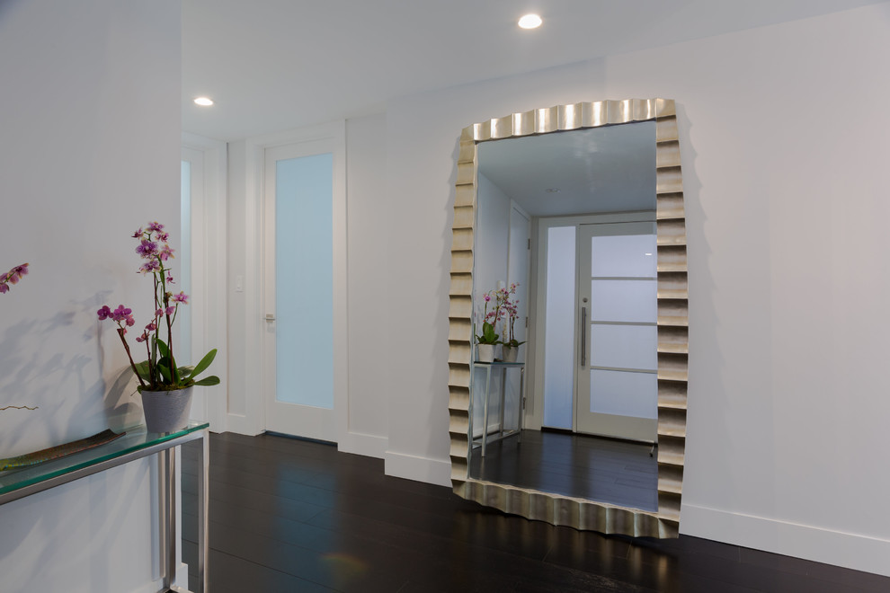 This is an example of a medium sized traditional hallway in Los Angeles with grey walls, dark hardwood flooring, a single front door and a glass front door.