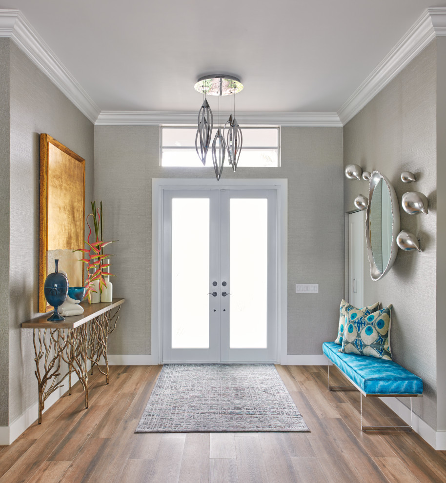 Immagine di un grande corridoio contemporaneo con pareti grigie, pavimento in legno massello medio, una porta a due ante, una porta bianca e pavimento marrone