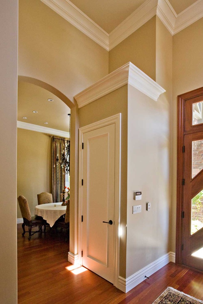 На фото: большая входная дверь в стиле фьюжн с бежевыми стенами, паркетным полом среднего тона, двустворчатой входной дверью, входной дверью из дерева среднего тона и коричневым полом