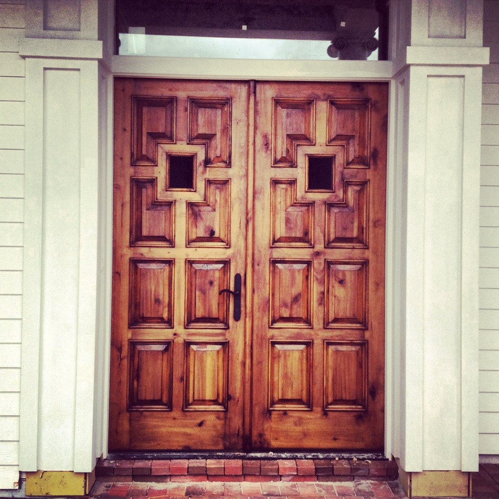 Exemple d'une porte d'entrée chic avec un mur blanc, un sol en brique, une porte double et une porte en bois foncé.